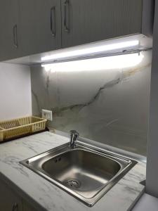 a kitchen sink with a light above it at Casa de Flori in Përmet