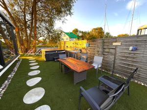 a backyard with a table and chairs and a fence at Futuristic Capsule - Private Jacuzzi & Beach access in Wapnica