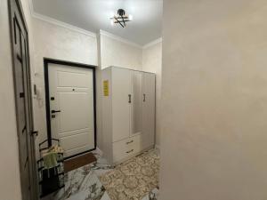 a bathroom with a white closet and a door at Жилой Комплекс Kemel-UI in Qaskeleng