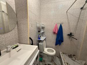 a bathroom with a sink and a toilet and a mirror at Жилой Комплекс Kemel-UI in Qaskeleng