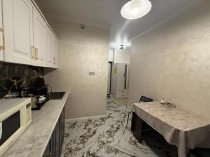 a kitchen with a table in the middle of it at Жилой Комплекс Kemel-UI in Qaskeleng