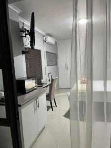 a kitchen with a table and a desk in a room at LINGAS inn in Richards Bay