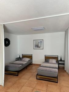 two beds in a room with white walls at Ferienwohnung in Ruppichteroth Winterscheid im EG mit Garten und Klima in Ruppichteroth