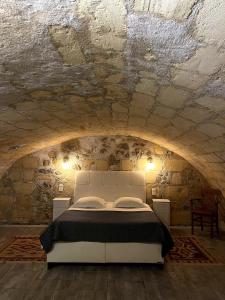 a bedroom with a white bed in a stone wall at Au 47 in Bordeaux