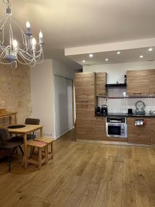 a large kitchen with a table and a chandelier at Au 47 in Bordeaux