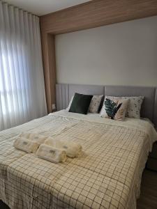 a bedroom with a bed with two towels on it at Apê Calma - 5min Consulado EUA - Garagem in Porto Alegre