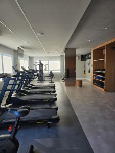a gym with a row of treadmills and machines at Apê Calma - 5min Consulado EUA - Garagem in Porto Alegre
