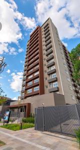 a tall building with a fence in front of it at Apê Calma - 5min Consulado EUA - Garagem in Porto Alegre