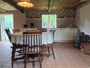 a kitchen with a table with chairs and a stove at Scandinavian forest retreat in Ljungbyhed