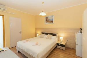 a bedroom with a large white bed and a refrigerator at Bed and breakfast Porto del Mar in Medulin