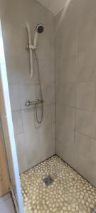 a bathroom with a shower with a tiled floor at Wooden chalet with splendid view in Fresse-sur-Moselle