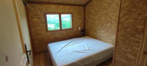a small bedroom with a bed and a window at Wooden chalet with splendid view in Fresse-sur-Moselle