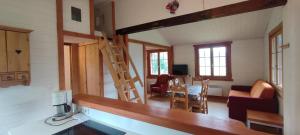 a kitchen and living room with a staircase in a tiny house at Wooden chalet with splendid view in Fresse-sur-Moselle