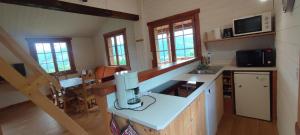 a kitchen with a counter and a table in a room at Wooden chalet with splendid view in Fresse-sur-Moselle +2 photos