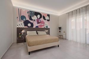 a bedroom with a bed with a painting on the wall at BellDuomo Suite Messina in Messina