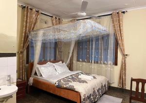 a bedroom with a canopy bed and a sink at Safari Resot Star One in Moshi