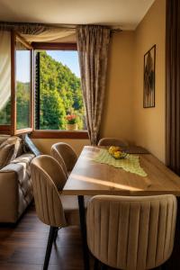 a dining room with a table and chairs and a window at Nature escape cottage in Cetinje