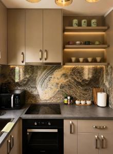 a kitchen with white cabinets and a black oven at Nature escape cottage in Cetinje