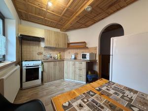 a kitchen with a table and a white refrigerator at Apartmán Lukáš in Ždiar