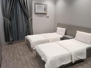 two beds in a hospital room with a window at شقق المجد الذهبي للشقق المخدومة in Quai
