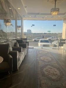 a living room with couches and a view of a parking lot at شقق المجد الذهبي للشقق المخدومة in Quai