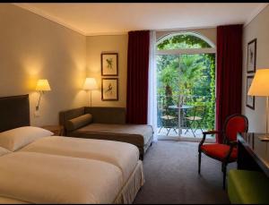a hotel room with two beds and a window at Villa Miravalle - Boutique Hotel in Riva del Garda +132 photos