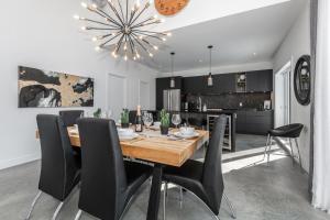 a dining room with a wooden table and black chairs at Luxurious Villa Tremblant 4 Bdrs W Hot Tub B85 in Mont-Tremblant