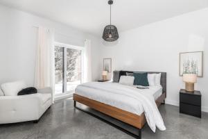 a white bedroom with a large bed and a white couch at Luxurious Villa Tremblant 4 Bdrs W Hot Tub B85 in Mont-Tremblant +34 photos