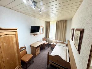 a room with a bedroom with a bed and a desk at Hotel Bauernstube in Oberhausen +10 photos