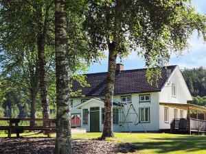 a white house with trees in front of it at 11 person holiday home in HÖGSÄTER-By Traum in Högsäter