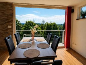 a dining room with a table and a large window at Ski- und Wanderurlaub im Wald Ferienhaus Adlerblick in Schnett