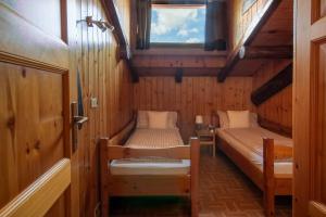 a small room with two beds and a window at The WoodHouse in Livigno