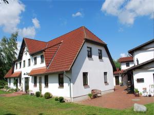 a large white house with a red roof at Großes Landhaus mit Swimmingpool in Dargun in Barlin