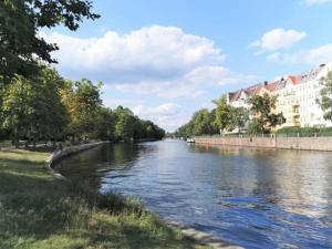 a river with buildings on the side of it at Großes Landhaus mit Swimmingpool in Dargun in Barlin +28 photos
