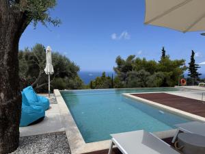 a swimming pool with a tree and an umbrella at Limestone House in Athani +43 photos