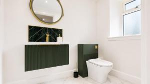 a bathroom with a toilet and a mirror at Modern Central 3 Bedroom House in Stranraer