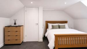 a bedroom with a large bed and a wooden dresser at Modern Central 3 Bedroom House in Stranraer