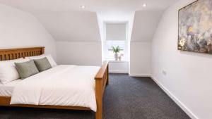 a bedroom with a bed and a painting on the wall at Modern Central 3 Bedroom House in Stranraer