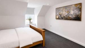 a bedroom with a bed and a painting on the wall at Modern Central 3 Bedroom House in Stranraer +5 photos
