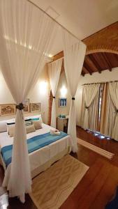 a bedroom with a bed with drapes at Hotel Pousada Chalé das Flores in Sertãozinho +232 photos