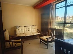 a living room with a couch and two chairs at APART TOSCANO Suites in Huancayo