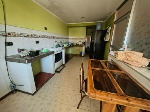 a kitchen with green walls and white counters at APART TOSCANO Suites in Huancayo