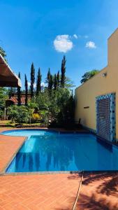 a swimming pool in front of a building at Hotel Pousada Chalé das Flores in Sertãozinho