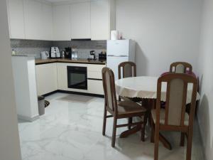 a kitchen with a table and chairs and a refrigerator at Apartman Ema in Bihać