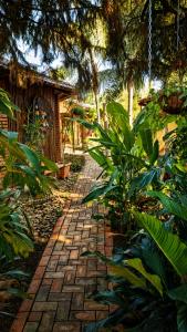 a brick walk way in a garden with plants at Hotel Pousada Chalé das Flores in Sertãozinho