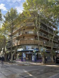 a tall building with trees in front of it at Apartamento Monte Grande Centro in Monte Grande