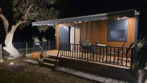 a house with a deck with two chairs and a table at Miarla Rooms in Borsh