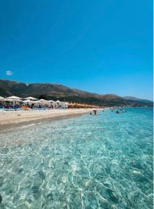 a beach with a group of people in the water at Miarla Rooms in Borsh