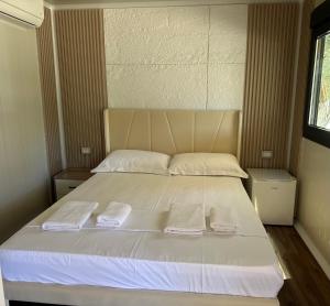 a bedroom with a bed with two towels on it at Miarla Rooms in Borsh