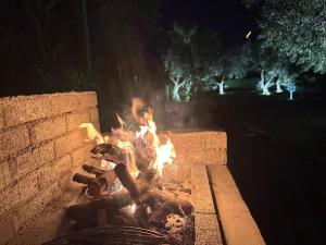 a fire in a brick fire pit at night at Miarla Rooms in Borsh
